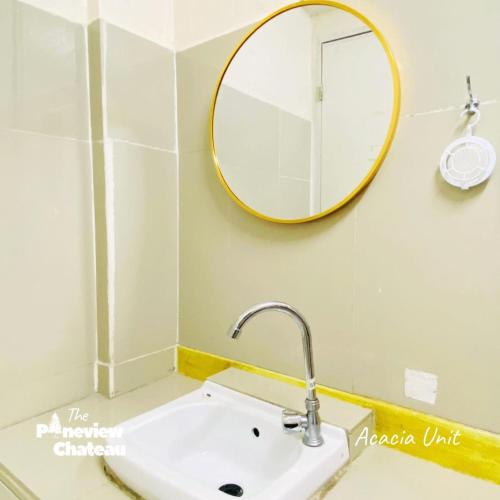 a bathroom with a sink and a mirror at Acacia Family Nook by The Pineview Chateau in Baguio