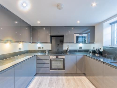 a large kitchen with white cabinets and appliances at Pass the Keys 4-Bedroom Seafront House in Southend Sea Views in Southend-on-Sea