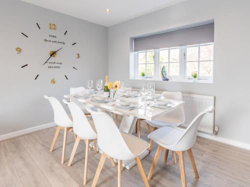 a white dining room with a white table and chairs at Pass the Keys 4-Bedroom Seafront House in Southend Sea Views in Southend-on-Sea