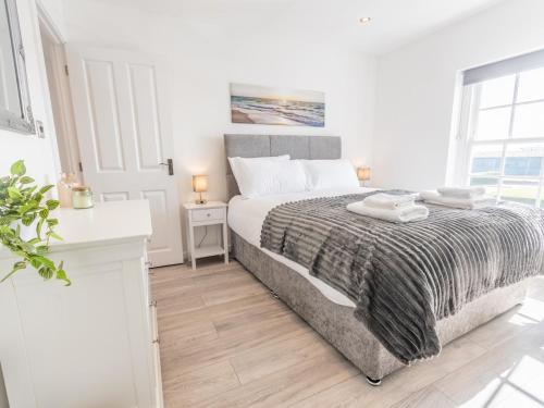 a white bedroom with a bed and a window at Pass the Keys 4-Bedroom Seafront House in Southend Sea Views in Southend-on-Sea