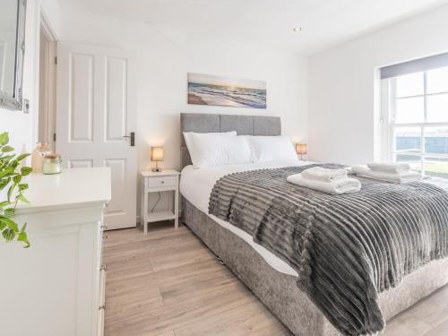 a white bedroom with a large bed and a window at Pass the Keys 4-Bedroom Seafront House in Southend Sea Views in Southend-on-Sea
