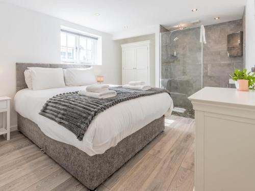 a bedroom with a large bed and a shower at Pass the Keys 4-Bedroom Seafront House in Southend Sea Views in Southend-on-Sea