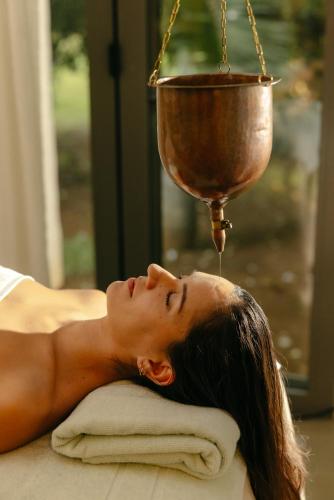 a woman laying on a pillow with a cup on top of her head at Long Beach Mauritius in Belle Mare