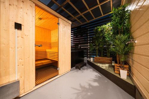 an outdoor sauna with plants in a wooden building at 真 サウナ付きの貸切宿 usjまで9分 無料駐車場 寝室3 ベッド8台 バスルーム2台 in Osaka
