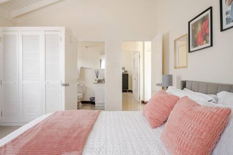 Old HarbourBellaRose at Colbeck ,Gated with Pool, Stylishly modern的卧室配有一张带粉红色枕头的大床
