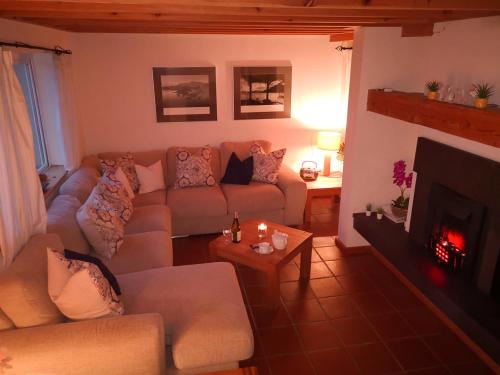 a living room with a couch and a fireplace at 4 bedroomed house in Waterville close to the beach in Waterville