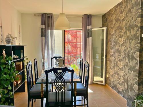 a dining room with a table and chairs and a window at Home4u Calle Barcelona in Armilla