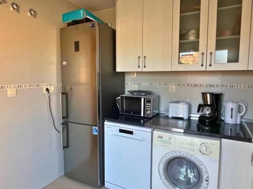 a kitchen with a refrigerator and a washing machine at Home4u Calle Barcelona in Armilla