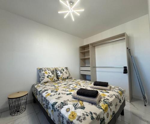 une chambre avec un lit et un ventilateur de plafond dans l'établissement Appartement 300m de la mer, à Valras-Plage