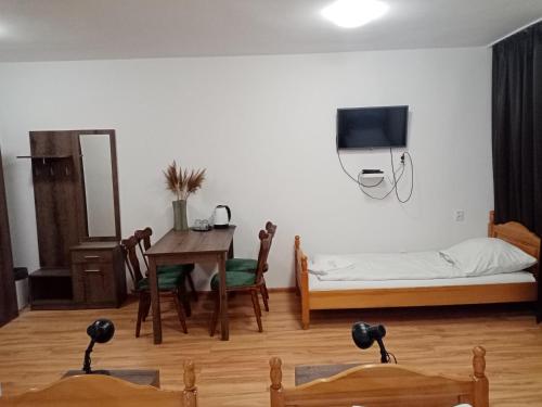 a living room with a bed and a table and a bedroom at Hotel Olimpik Park in Słubice