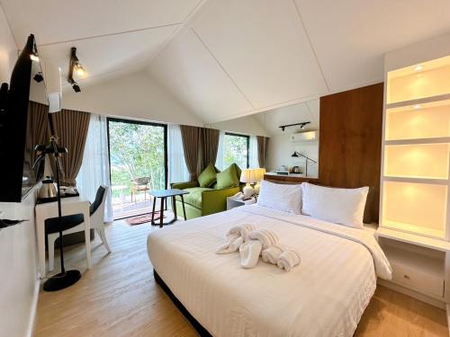a bedroom with a bed with towel animals on it at Chiangkhan River Green Hill in Ban Noi