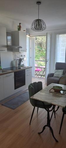 Il comprend une cuisine et un salon avec une table. dans l'établissement Orienté Nord frais bien ventilé grand studio balcon wifi parking vue étage supérieur, à Amélie-les-Bains-Palalda