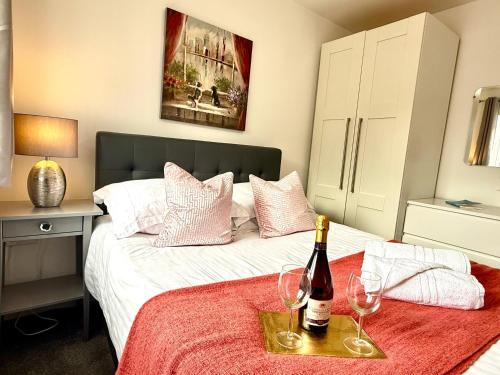 a bed with a bottle of wine and two glasses at Walnut Flats-F5, Stylish 1-Bedroom - Parking, Netflix, WIFI - Close to Oxford, Bicester & Blenheim Palace in Kidlington