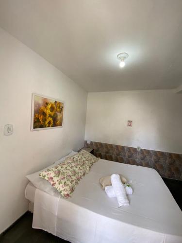a bedroom with a white bed with towels on it at Pousada da Bia in Rio das Ostras