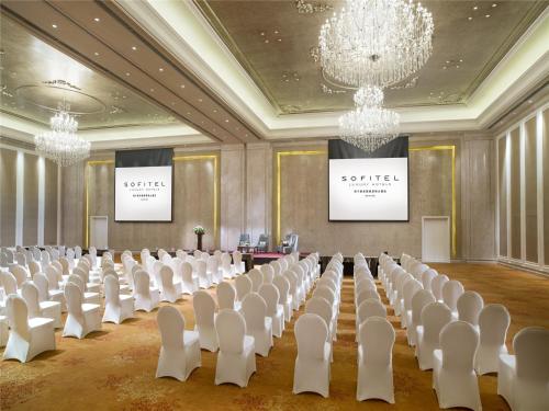 a conference room with white chairs and a projection screen at The Sebel Xining-Managed By Sofitel in Xining