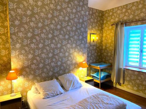 1 dormitorio con cama y pared con papel pintado con motivos florales en Le gite du gue, en Les Hautes-Rivières