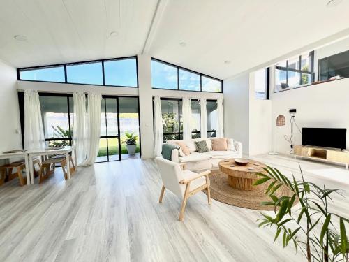 a living room with a couch and a table at Amazing Ocean Villa close to Natural Rock Pools in Sydney
