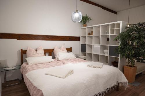 a bedroom with a large bed with white sheets at Hinterhaus in Herdwangen