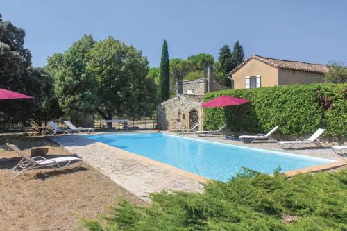une piscine avec chaises et parasols devant une maison dans l'établissement Domaine familial avec grand parc et piscine, à Mondragon