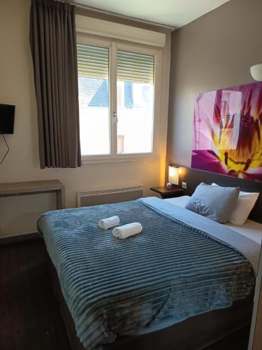 a bedroom with a bed with two towels on it at Hôtel De La Gare Périgueux in Périgueux