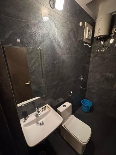 a bathroom with a sink and a toilet and a mirror at Skyfarm Resort in Barāgaon
