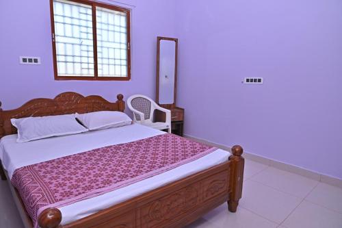 a bedroom with a wooden bed and a mirror at Kavitha Family Home stay TVM in Tiruvannāmalai