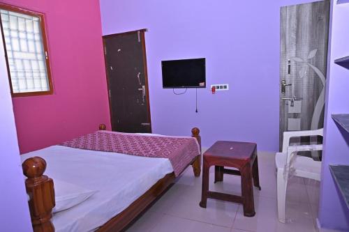 a small bedroom with a bed and a tv at Kavitha Family Home stay TVM in Tiruvannāmalai