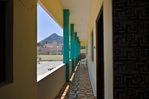 a hallway with green columns and a view of a courtyard at Kavitha Family Home stay TVM in Tiruvannāmalai