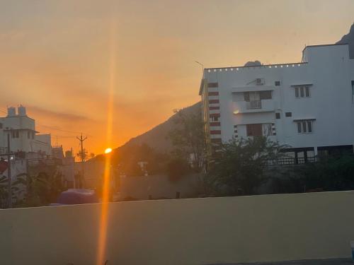 a sunset over a city with a white building at Kavitha Family Home stay TVM in Tiruvannāmalai