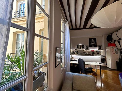 un salon avec une table et une fenêtre dans l'établissement Superbe et inoubliable Appart Le Marais Paris, à Paris