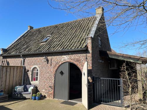a red brick building with a large garage at Het Bakkers Hutje in Vortum-Mullem