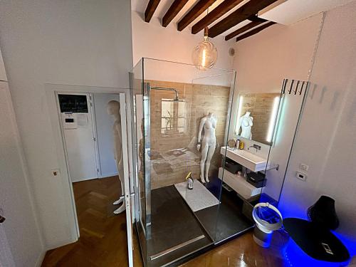 La salle de bains est pourvue d'une douche en verre avec une statue. dans l'établissement Superbe et inoubliable Appart Le Marais Paris, à Paris