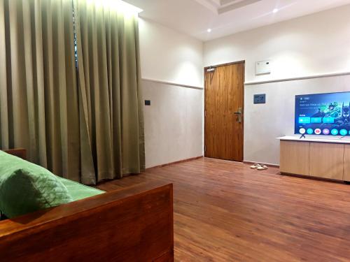 a bedroom with a bed and a flat screen tv at Gulzar 1BHK Service Apartment, kannur in Kannur