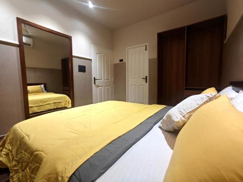a bedroom with two beds and a large mirror at Gulzar 1BHK Service Apartment, kannur in Kannur