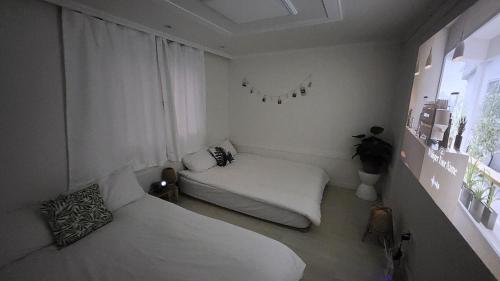 ein kleines Zimmer mit zwei Betten und einem Fenster in der Unterkunft Green Bring in Daegu
