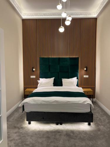 een slaapkamer met een groot bed met een groen hoofdeinde bij Apartment Deluxe Bucharest Downtown in Boekarest