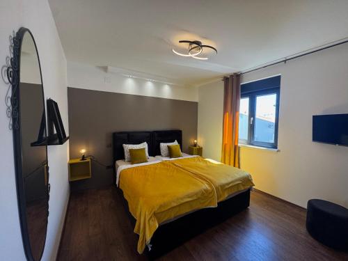 a bedroom with a bed with a yellow blanket at Golden Sunset 3 in Njivice