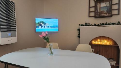 Zimmer mit einem Tisch und einem TV an der Wand in der Unterkunft Green Bring in Daegu
