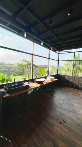 a large room with a counter with sinks and windows at Đen Hill Home The Wooden in Ðại Lào