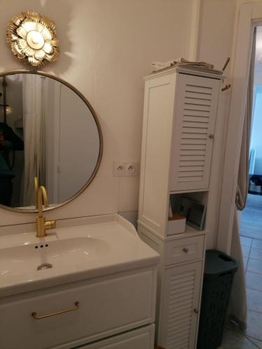 une salle de bain avec un lavabo et un miroir dans l'établissement T3 spacieux à 150m de la plage, à Canet