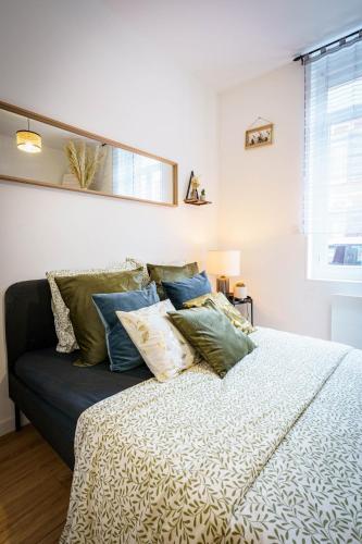 une chambre avec un lit avec des oreillers dessus dans l'établissement Charmant F2 Wifi centre 3Pers, à Saint-Quentin