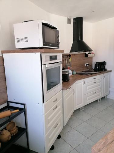 une cuisine avec un micro-ondes et un plan de travail dans l'établissement T3 spacieux à 150m de la plage, à Canet