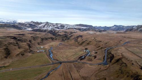 an aerial view of a road in the mountains at Paradise Cottages in Vík
