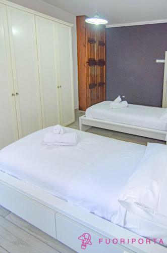 a bedroom with two beds with white sheets at Casa di Stefania in Parma