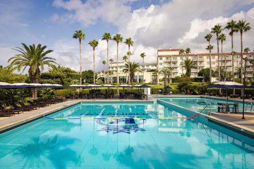 a pool at a resort with palm trees at Kensington Resort Seogwipo in Seogwipo