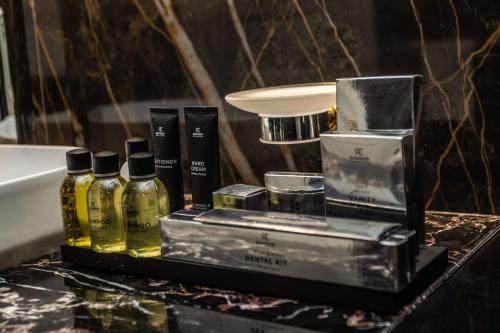 a bathroom counter with perfume bottles and a sink at Radisson Collection Morina Hotel, Tirana in Tirana