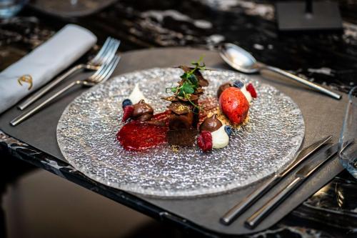 a plate with strawberries and chocolate on a table at Radisson Collection Morina Hotel, Tirana in Tirana