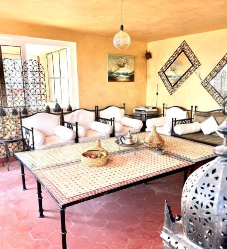 a living room with a table and couches at Town Gate in Tamraght Ouzdar