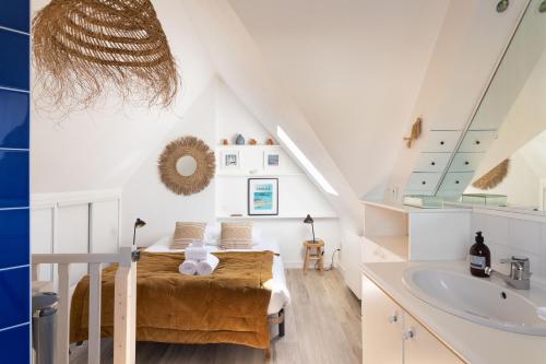 - une chambre mansardée avec un lit et un lavabo dans l'établissement Le Tourmentin - Vue Port, à Saint-Malo