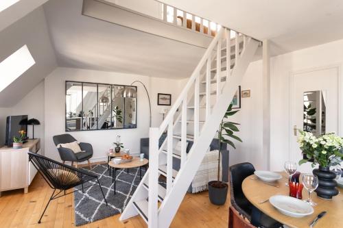 - un salon avec un escalier, une table et des chaises dans l'établissement Le Tourmentin - Vue Port, à Saint-Malo